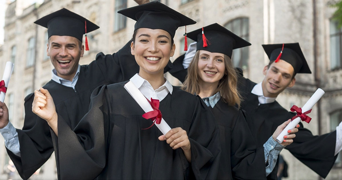 Groupe de quatre jeunes diplômés très fiers d'avoir eu leur diplôme